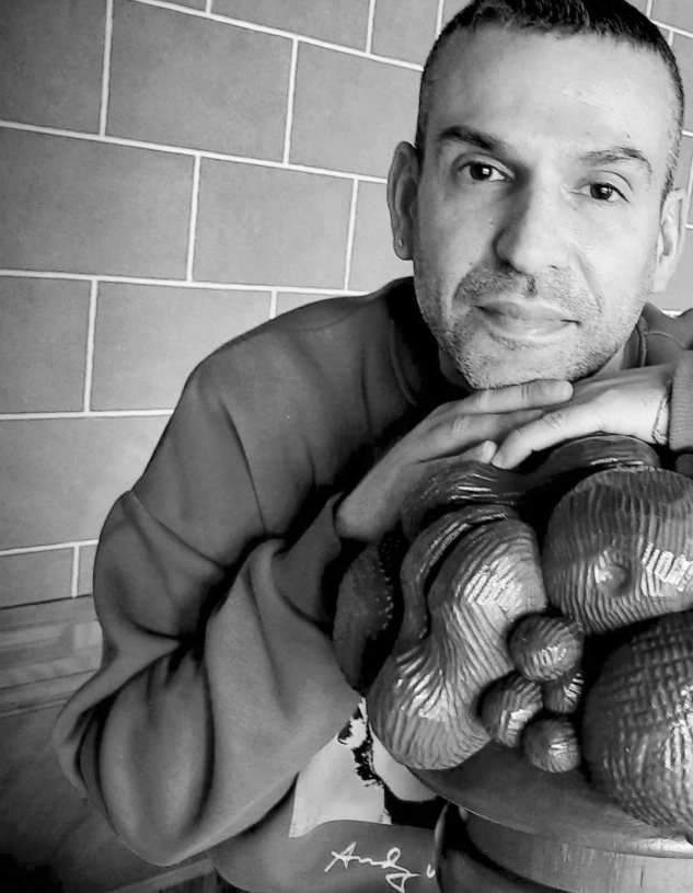 Foto de Claudio apoyado en una escultura